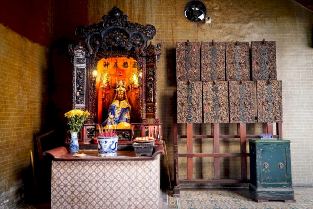 The side altars, adorned in red and gold, are where worshippers pray for prosperity and protection